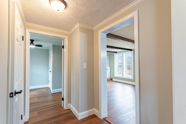 hallway featuring ornamental molding, beam ceiling, hardwood / wood-style floors, and a textured ceiling