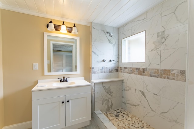 bathroom with a tile shower, vanity, ornamental molding, and wooden ceiling