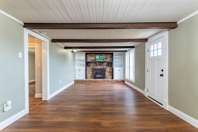 unfurnished living room with dark hardwood / wood-style flooring, a fireplace, beam ceiling, and built in shelves