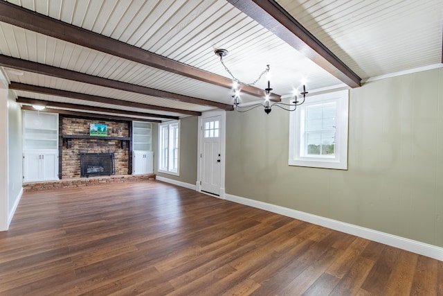 unfurnished living room featuring hardwood / wood-style floors, a chandelier, a wealth of natural light, and beam ceiling