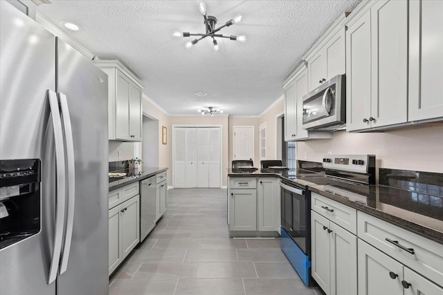 6961 Wittenham Cv, Memphis, TN 38119 - kitchen featuring light tile patterned flooring, a textured ceiling, dark stone counters, ornamental molding, and stainless steel appliances