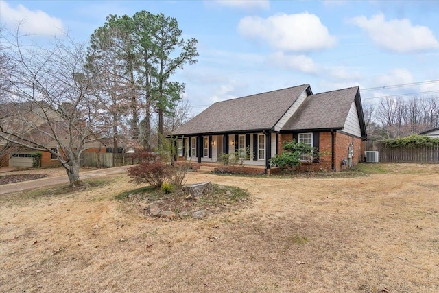 view of front of house with central AC unit, covered porch, and a front lawn