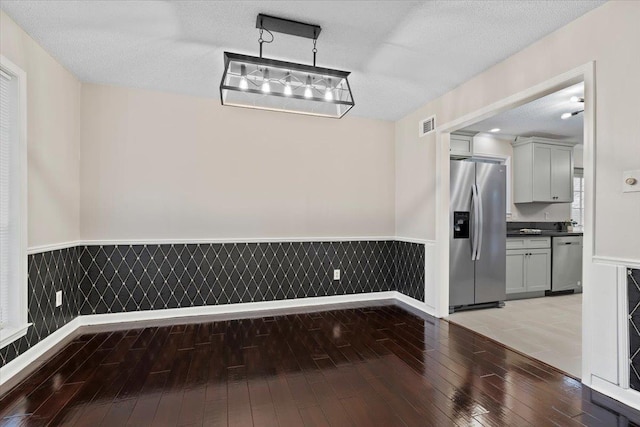 6961 Wittenham Cv, Memphis, TN 38119 - unfurnished dining area featuring wood-type flooring and a textured ceiling