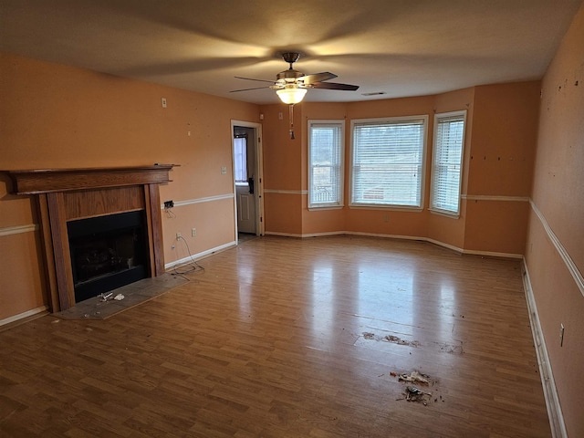 unfurnished living room with ceiling fan and wood-type flooring