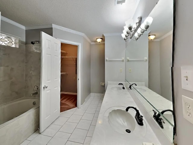 bathroom with tile patterned floors, crown molding, a textured ceiling, vanity, and tiled shower / bath combo