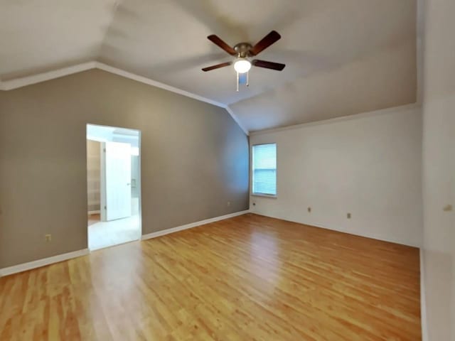 empty room with crown molding, ceiling fan, light hardwood / wood-style floors, and vaulted ceiling