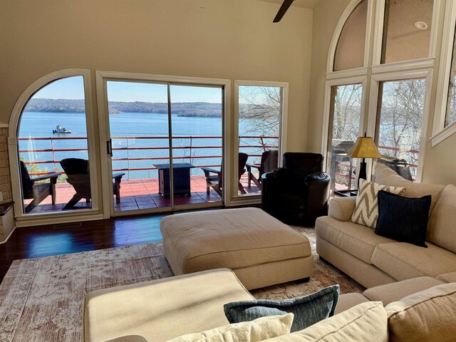 living room with a water view, dark hardwood / wood-style floors, and a high ceiling