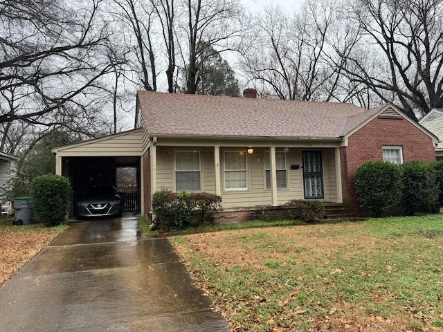 ranch-style home with a front lawn and a carport