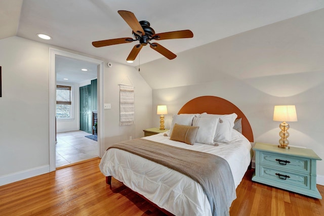 bedroom with lofted ceiling, light hardwood / wood-style floors, and ceiling fan