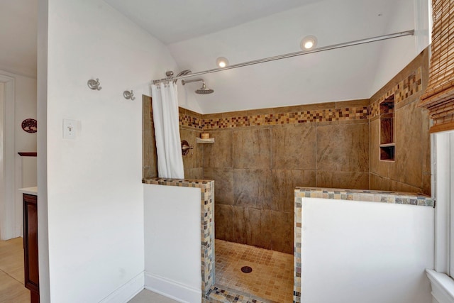 bathroom with vanity, lofted ceiling, and walk in shower