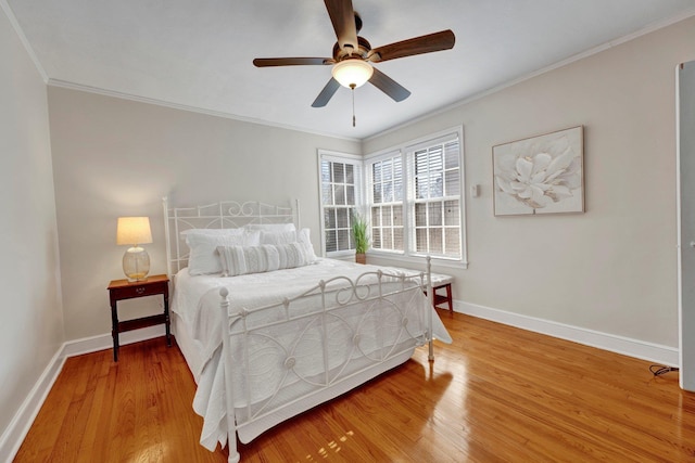 bedroom with hardwood / wood-style floors, ornamental molding, and ceiling fan