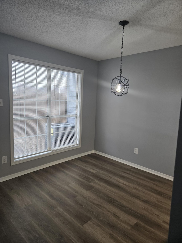 unfurnished dining area with dark hardwood / wood-style floors and a textured ceiling