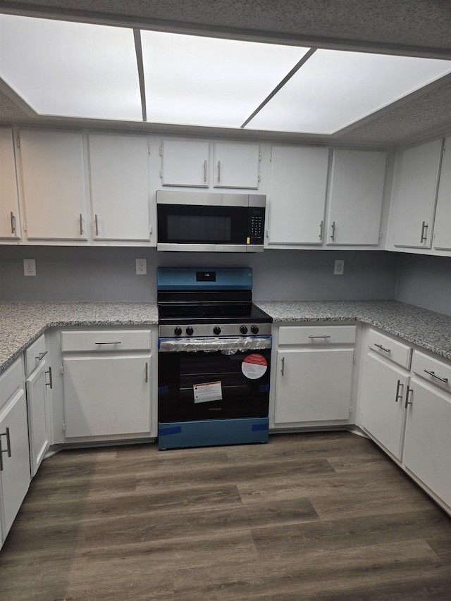 kitchen featuring white cabinetry, appliances with stainless steel finishes, and dark wood-type flooring