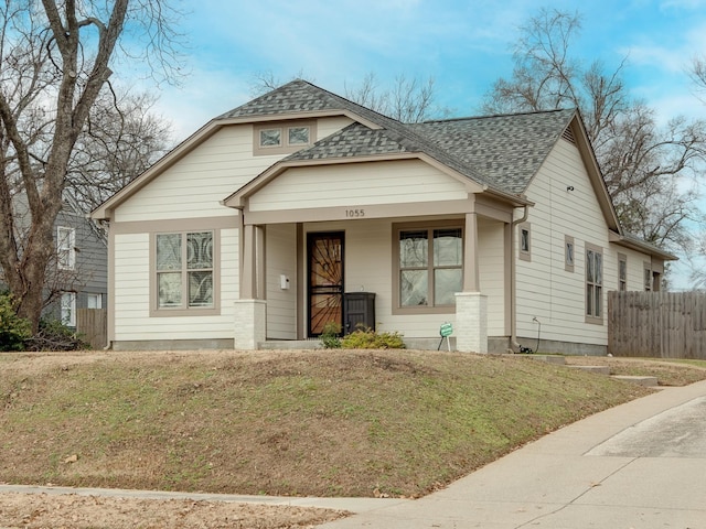 bungalow-style home featuring covered porch and a front lawn