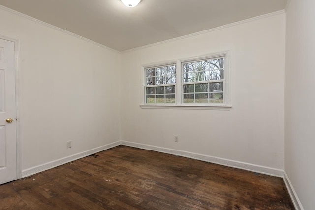 spare room featuring crown molding and dark hardwood / wood-style floors