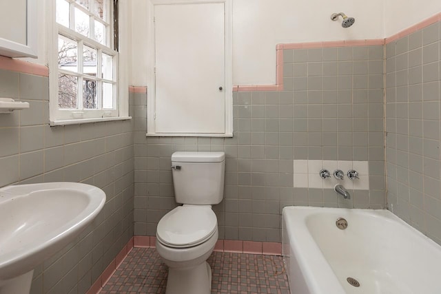 bathroom featuring a bathing tub, sink, tile walls, toilet, and tile patterned floors