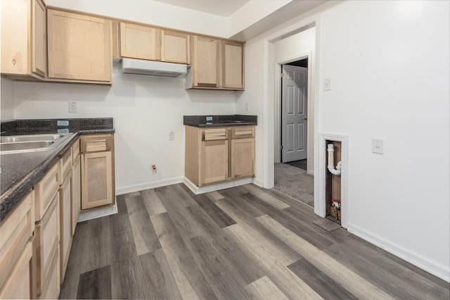 kitchen featuring dark wood-type flooring, dark stone countertops, sink, and light brown cabinets