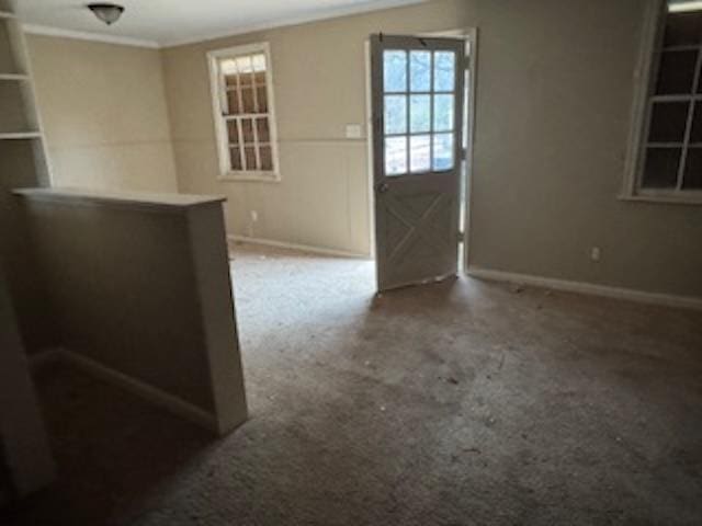 entrance foyer featuring crown molding and carpet