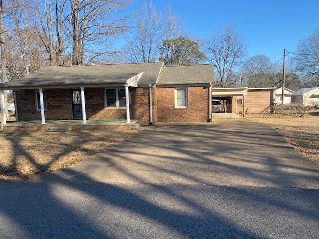 single story home featuring a carport and covered porch