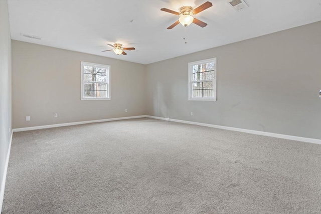 carpeted spare room with plenty of natural light and ceiling fan