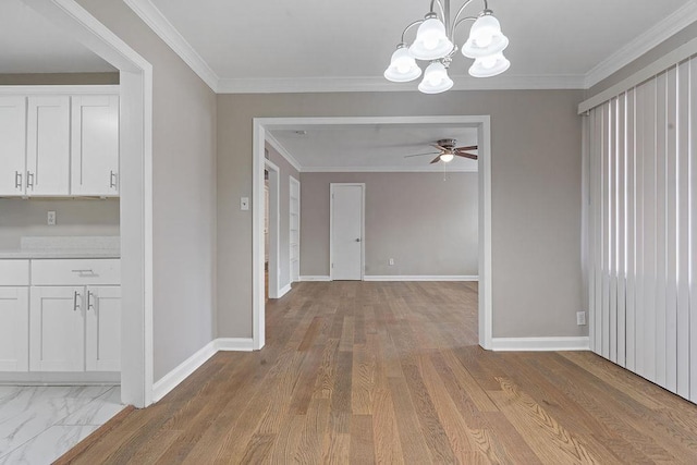 unfurnished dining area with crown molding, ceiling fan with notable chandelier, and light wood-type flooring