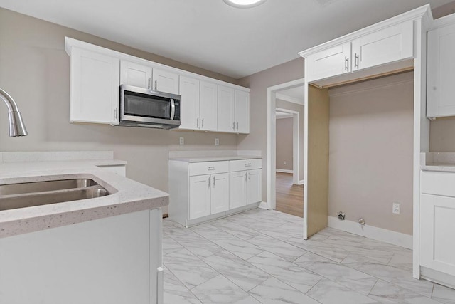 kitchen featuring sink and white cabinets