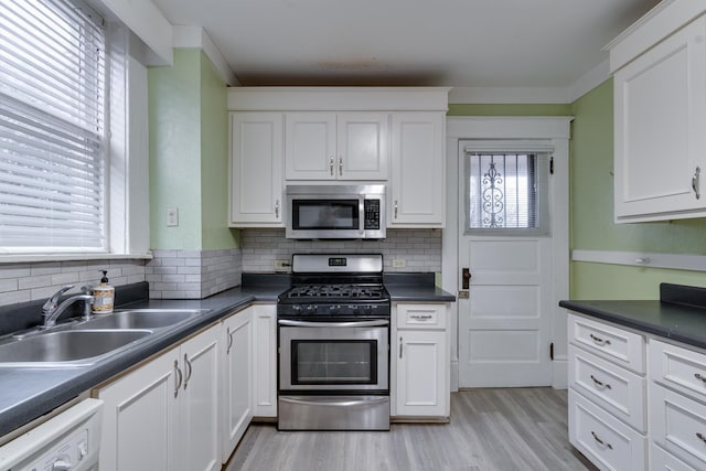 kitchen with stainless steel appliances, white cabinetry, and sink