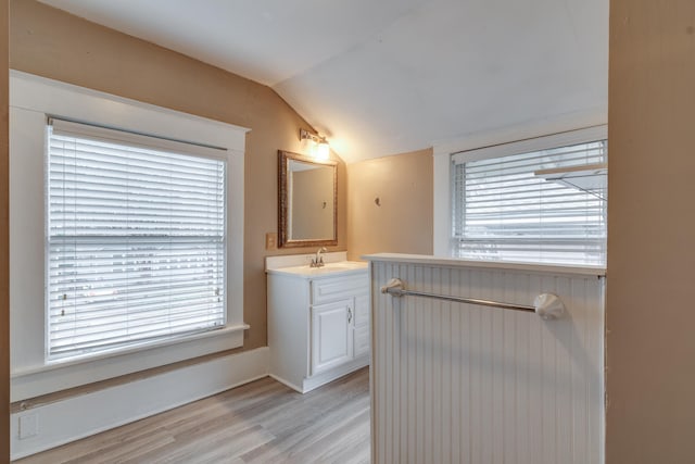 bathroom featuring hardwood / wood-style flooring, lofted ceiling, and vanity