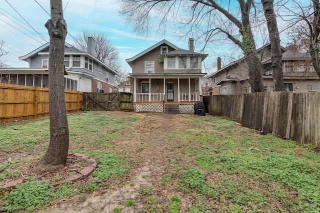 rear view of property featuring a porch and a yard