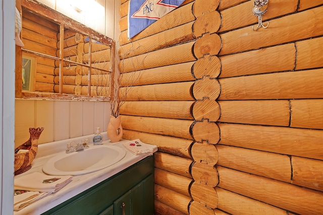 bathroom featuring vanity and rustic walls