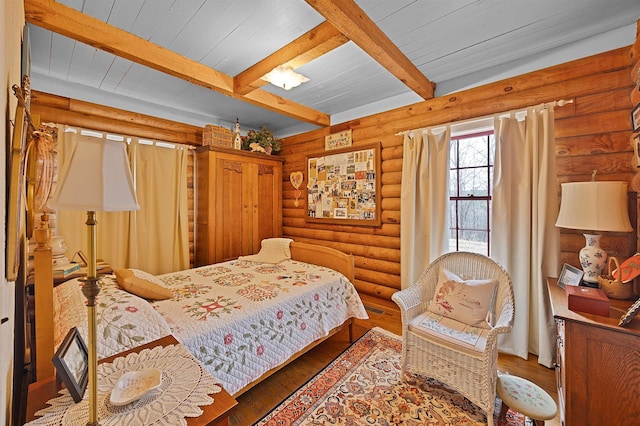 bedroom with log walls, wood ceiling, hardwood / wood-style flooring, and beamed ceiling