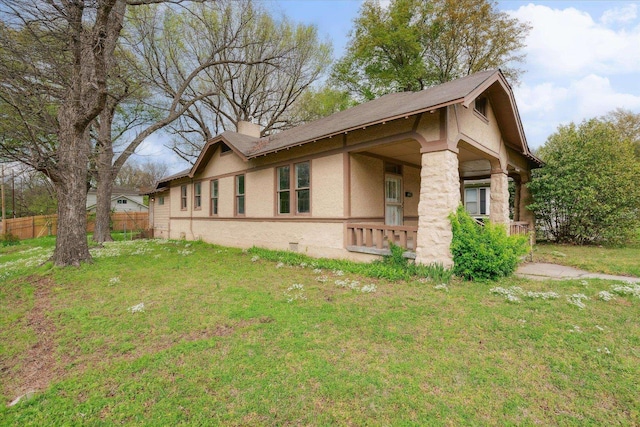 view of property exterior with a porch and a lawn