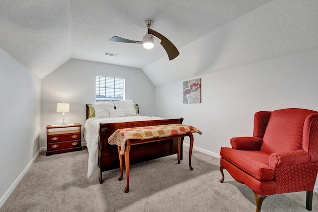 bedroom with vaulted ceiling, light carpet, ceiling fan, and a textured ceiling