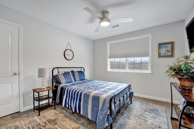 carpeted bedroom featuring ceiling fan and a textured ceiling