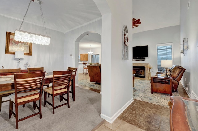 tiled dining room with crown molding and an inviting chandelier