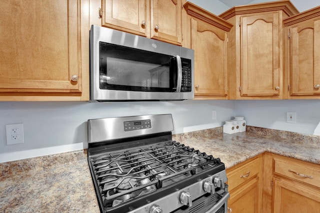 kitchen with light brown cabinets and appliances with stainless steel finishes