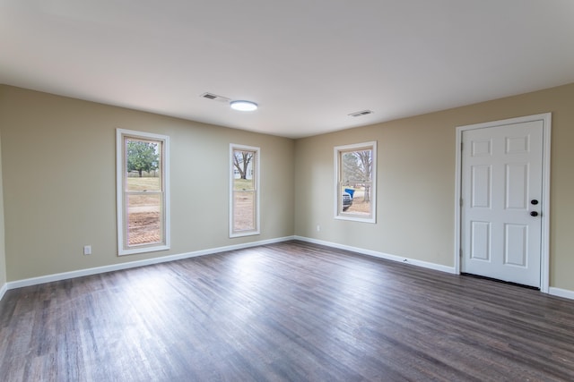 unfurnished room featuring dark hardwood / wood-style floors and a healthy amount of sunlight