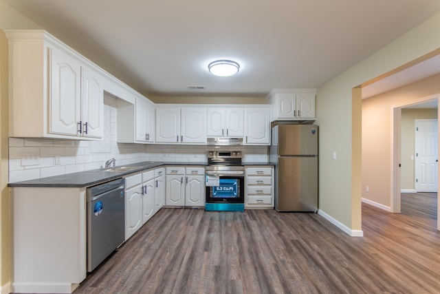 kitchen with sink, white cabinetry, tasteful backsplash, appliances with stainless steel finishes, and hardwood / wood-style floors