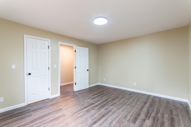 unfurnished bedroom with dark hardwood / wood-style flooring