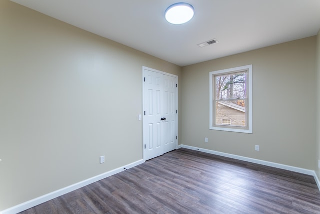 unfurnished room featuring dark wood-type flooring