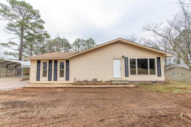 back of property with a carport