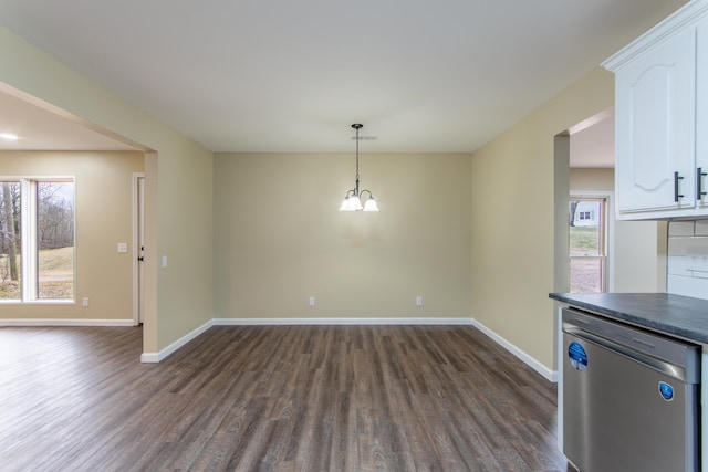 unfurnished dining area with dark wood-type flooring and a notable chandelier