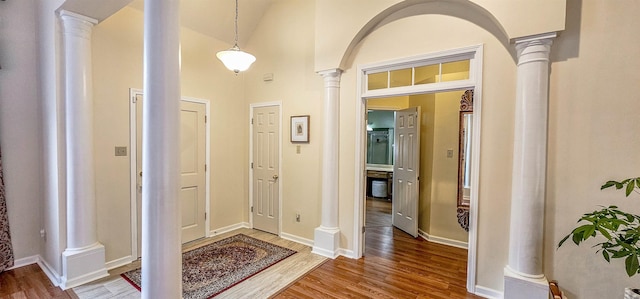 entrance foyer with hardwood / wood-style flooring, decorative columns, and a high ceiling