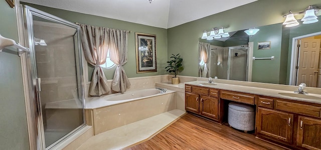 bathroom with vanity, hardwood / wood-style floors, lofted ceiling, and independent shower and bath