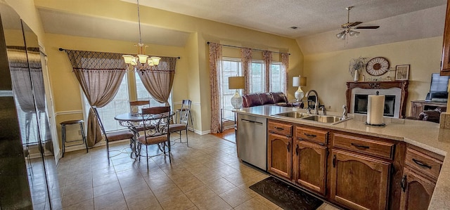 kitchen featuring lofted ceiling, sink, ceiling fan with notable chandelier, decorative light fixtures, and stainless steel dishwasher