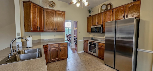 kitchen featuring stainless steel appliances, sink, light tile patterned floors, and ceiling fan