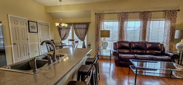 kitchen featuring lofted ceiling, sink, hanging light fixtures, dark hardwood / wood-style floors, and a chandelier