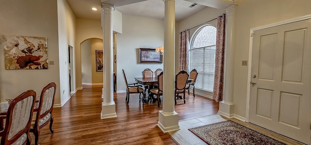 dining area featuring hardwood / wood-style floors and decorative columns