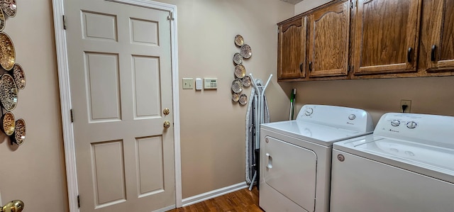 washroom featuring cabinets, washing machine and dryer, and dark hardwood / wood-style floors