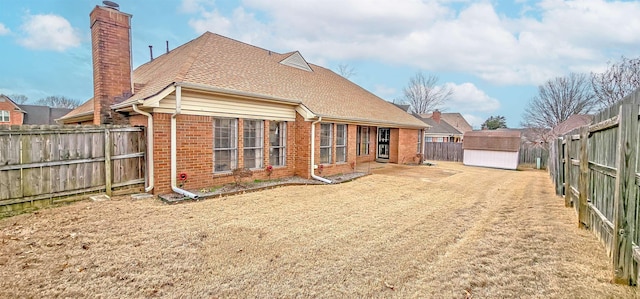 rear view of house featuring a storage unit